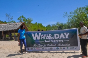 Agnes Ngonyo of ANAW (Left) Helps Display the Event’s Banner